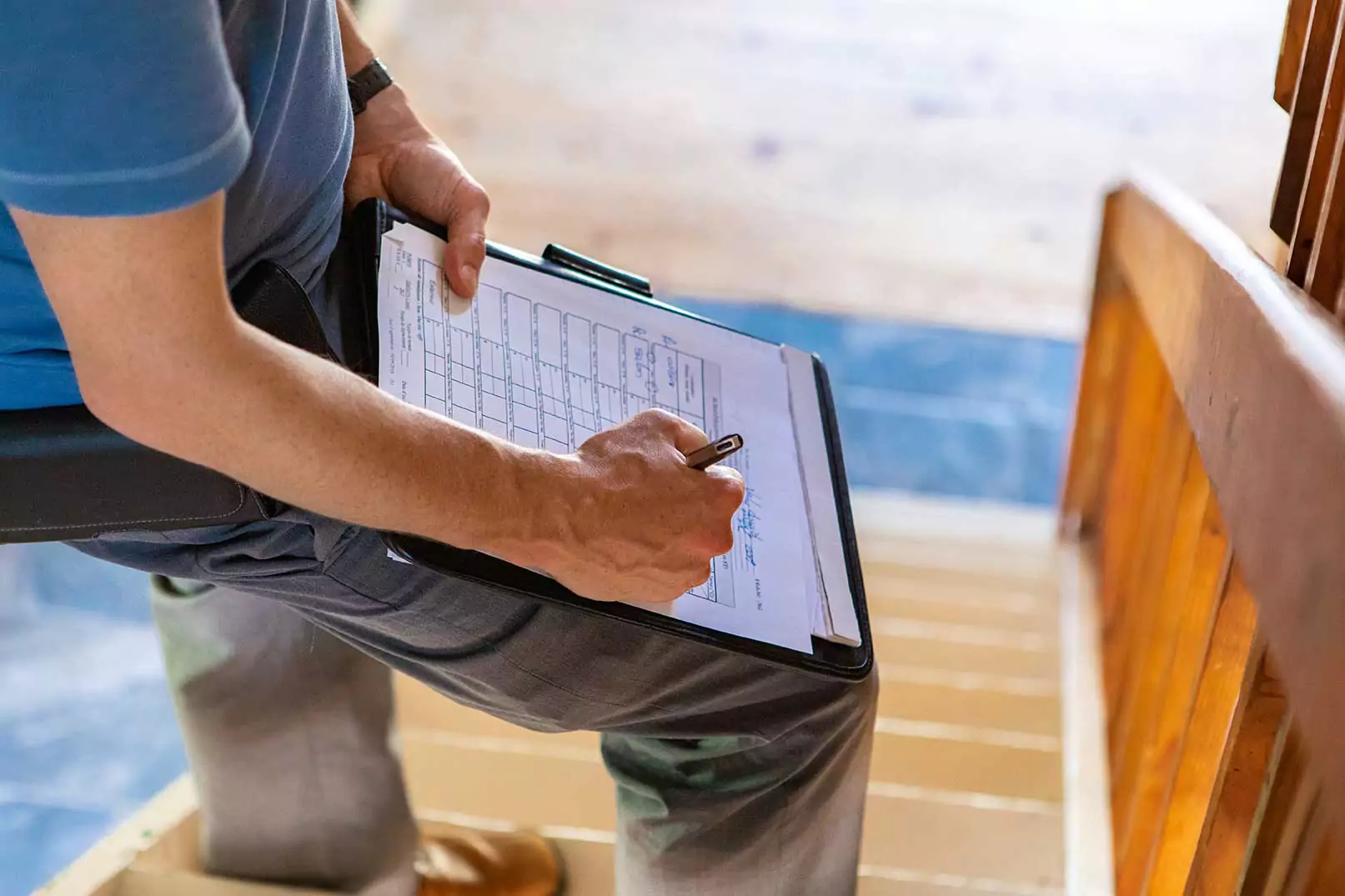 A person is holding a clipboard with a pen, likely conducting an inspection