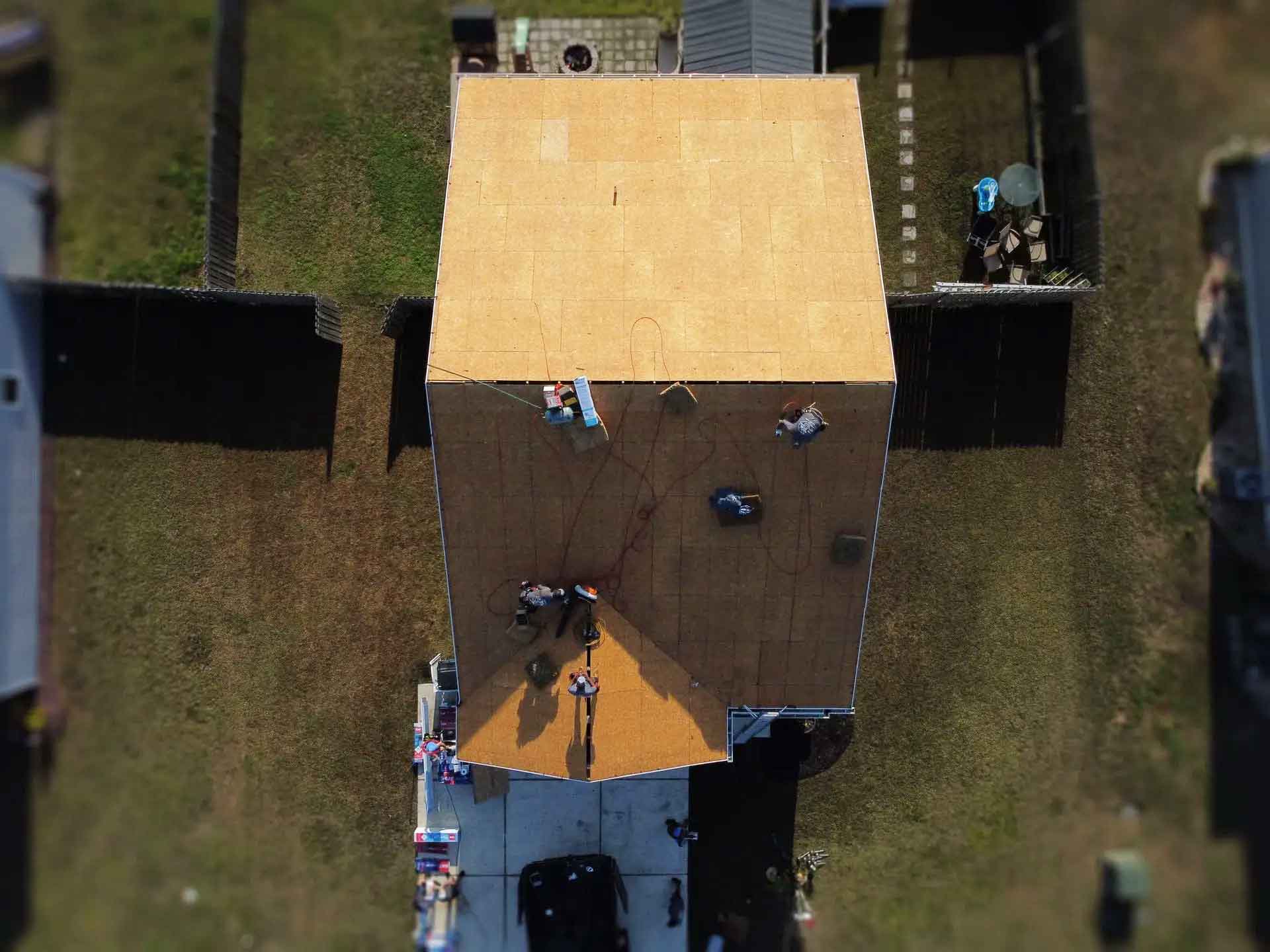 Aerial view of a house with a brown roof and a yellow awning