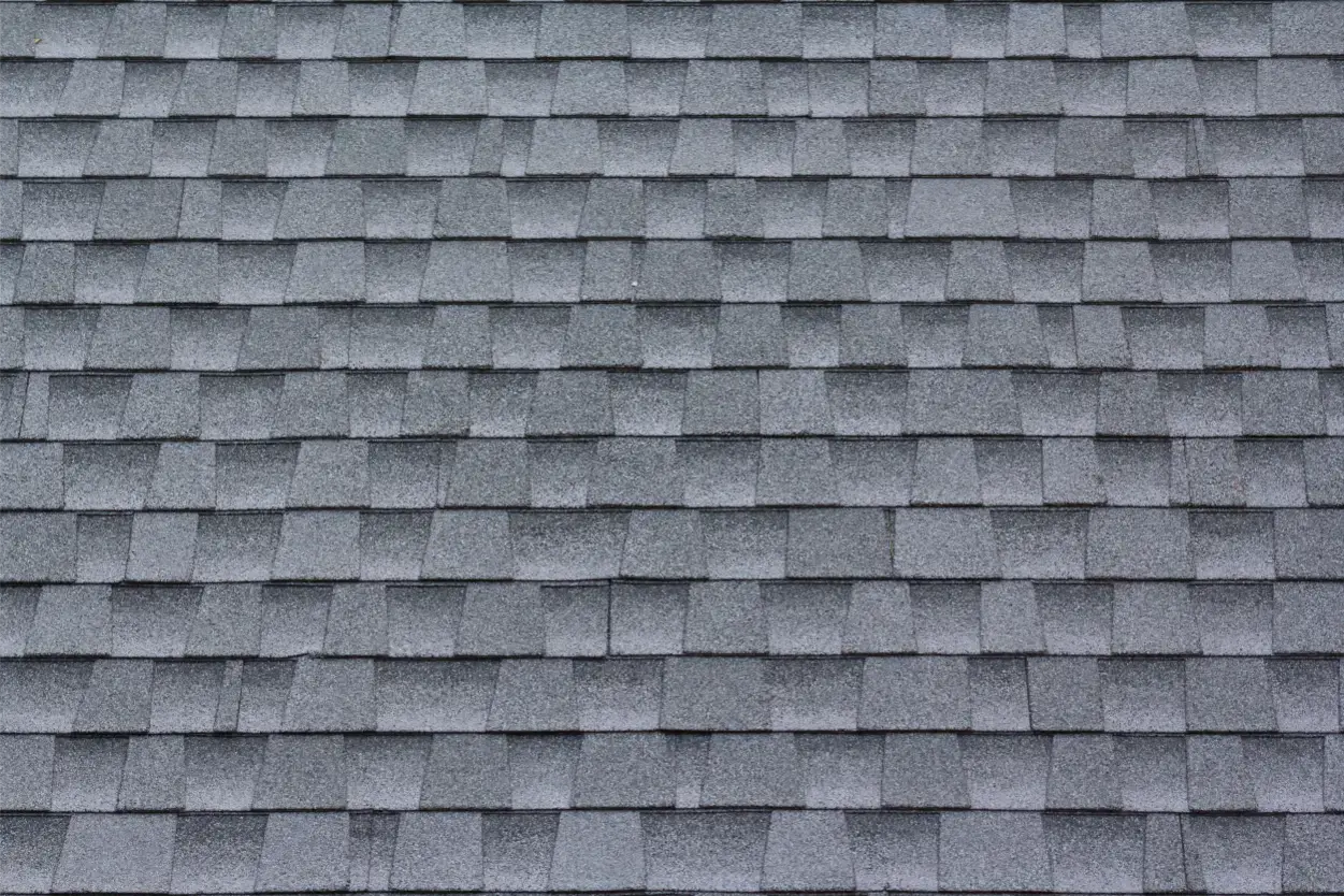 A gray shingle roof with multiple rows of rectangular, overlapping tiles